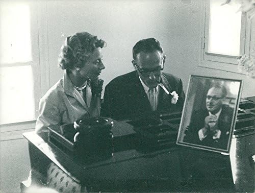 תצלום וינטג 'של גבר עם סיגריה ואישה יושבת בפסנתר.